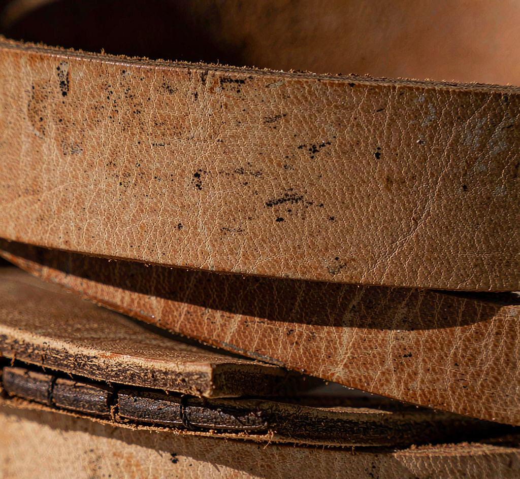 Close-up of a cutaway layered gun belt showing two bonded leather plies with a reinforced stiff core between them